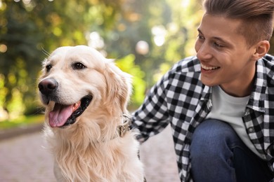 Photo of Portrait of happy owner with cute Golden Retriever dog outdoors