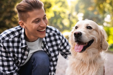 Photo of Portrait of happy owner with cute Golden Retriever dog outdoors