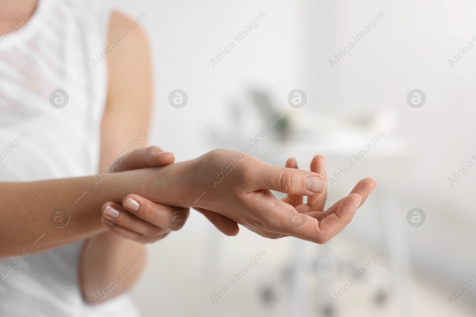 Photo of Sports injury. Woman with pain in wrist in hospital, closeup