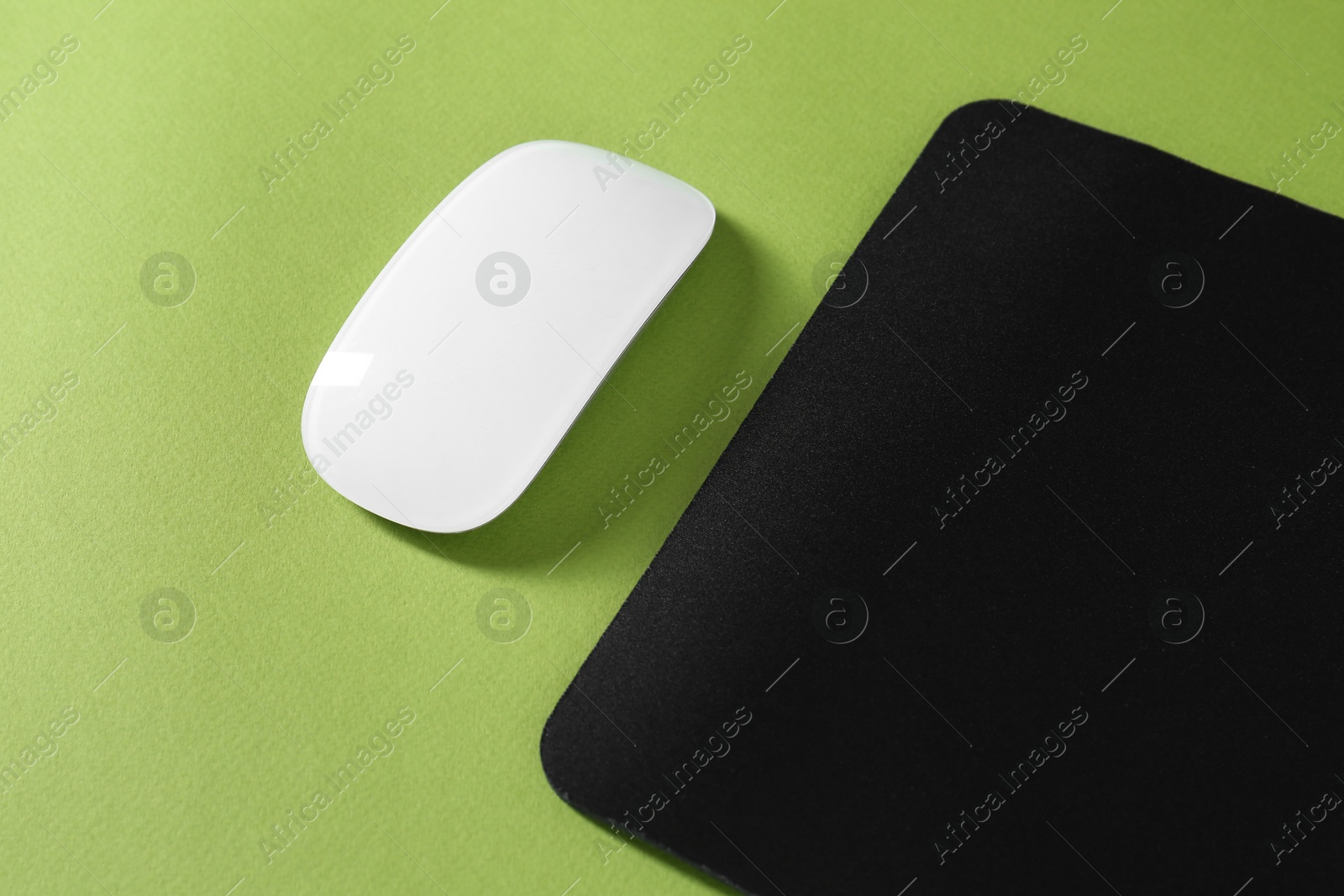 Photo of Wireless mouse and mousepad on green background