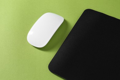 Photo of Wireless mouse and mousepad on green background