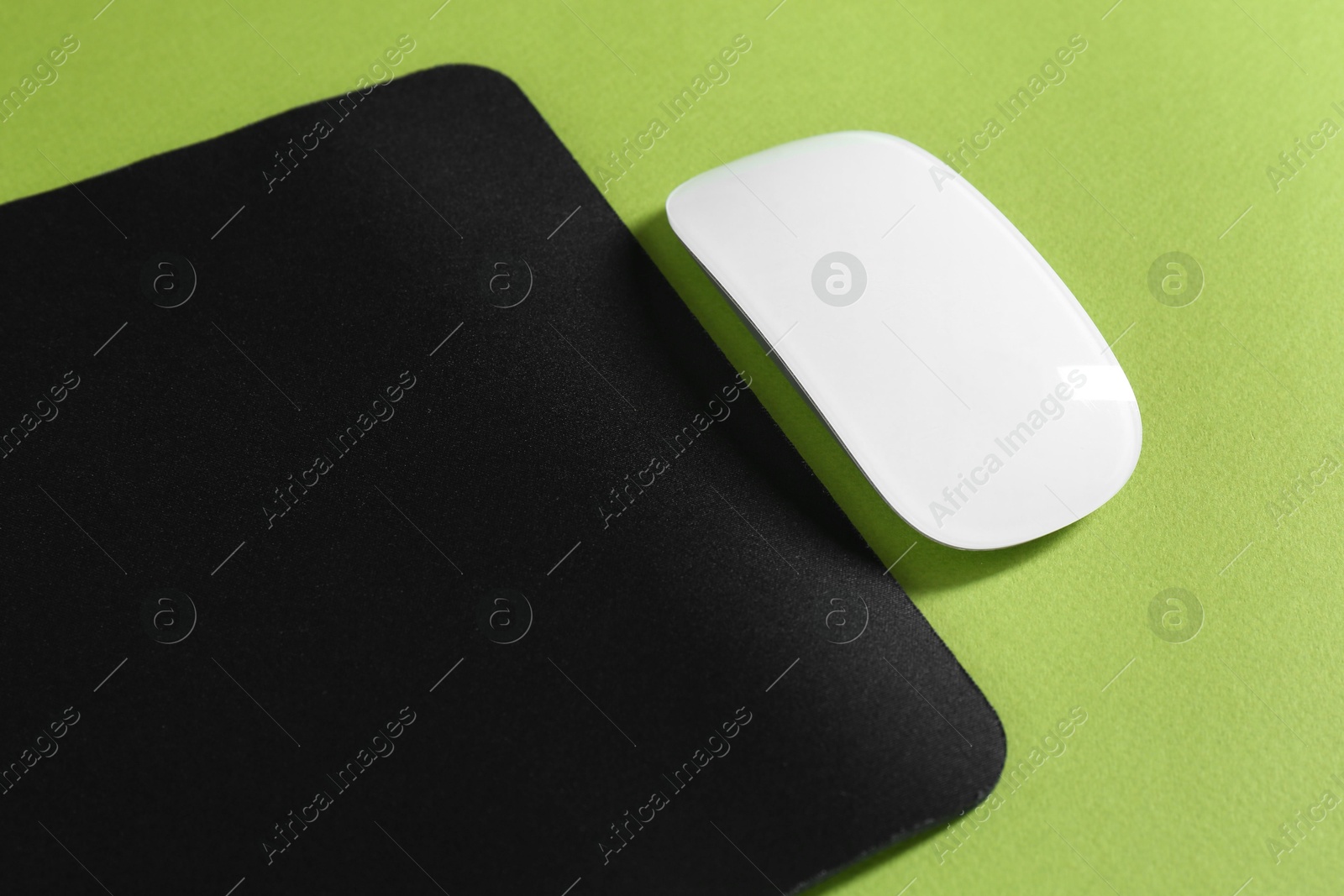 Photo of Wireless mouse and mousepad on green background