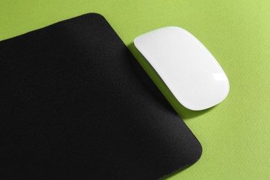 Photo of Wireless mouse and mousepad on green background