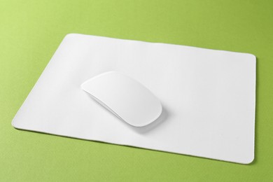 Wireless mouse and mousepad on green background