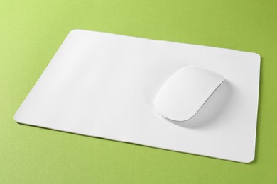 Wireless mouse and mousepad on green background