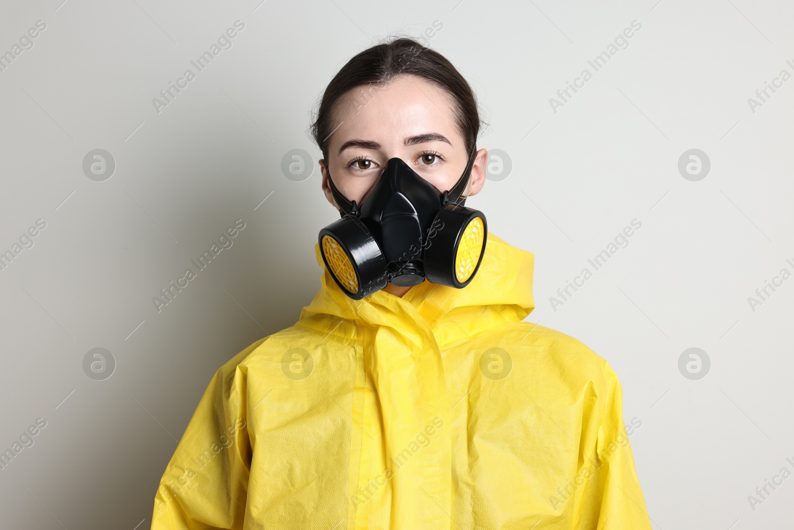 Photo of Worker in respirator and protective suit on grey background