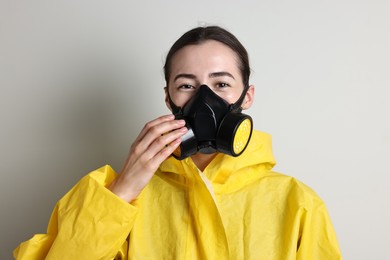 Photo of Worker in respirator and protective suit on grey background
