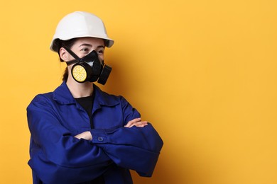 Photo of Worker in respirator and helmet on orange background, space for text