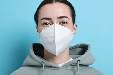 Photo of Woman in respirator mask on light blue background