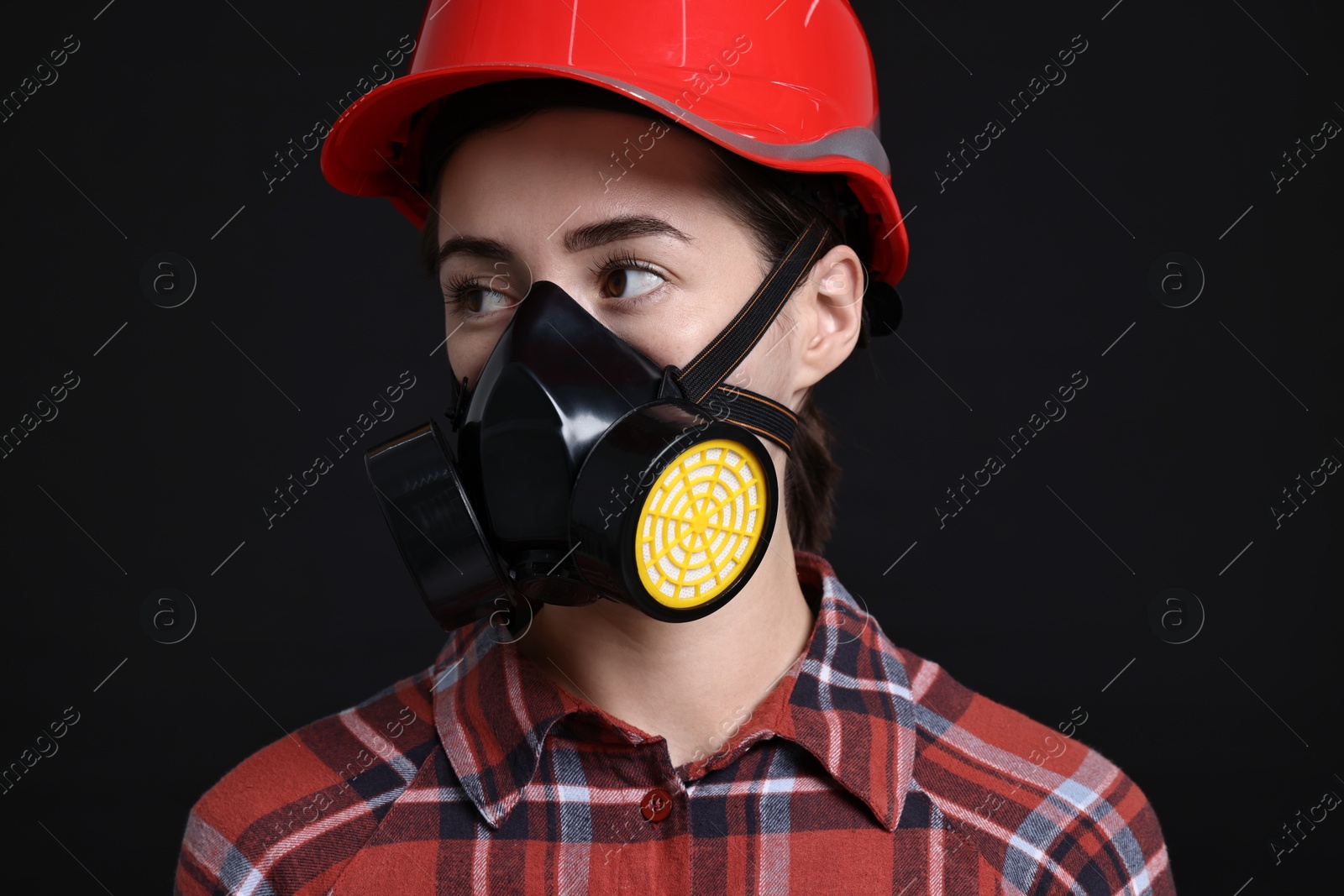 Photo of Woman in respirator and helmet on black background