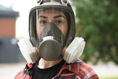 Photo of Woman in respirator mask outdoors. Protective equipment