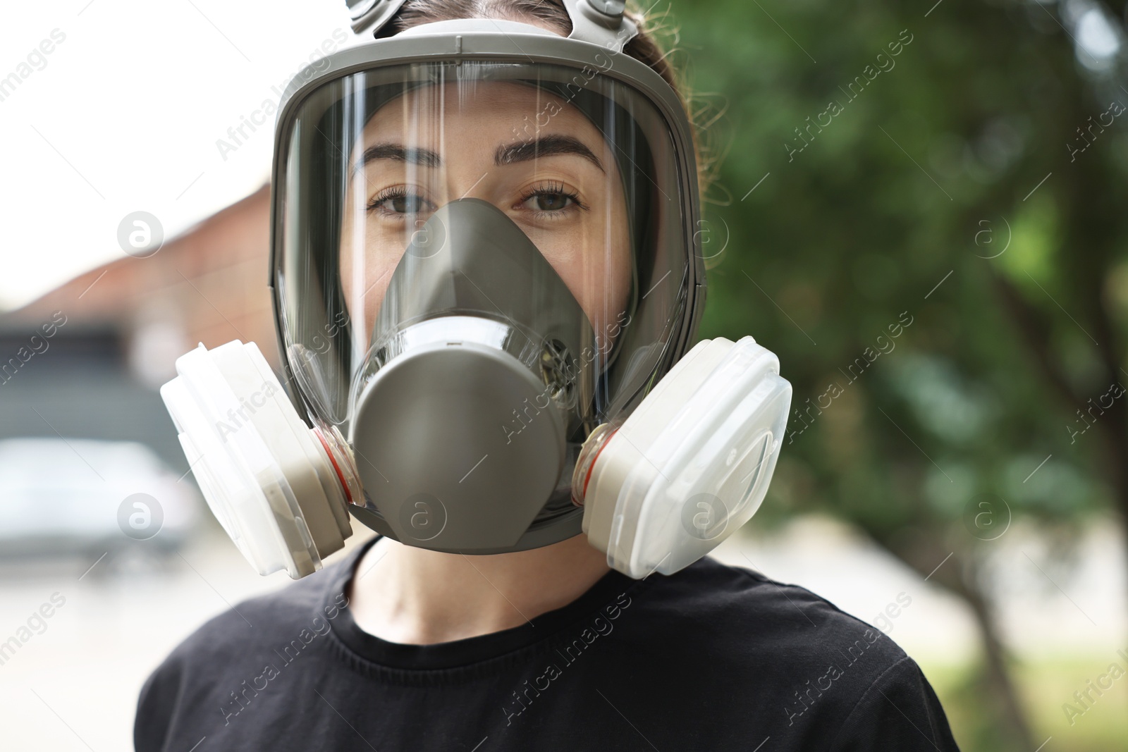 Photo of Woman in respirator mask outdoors. Protective equipment