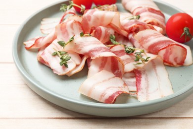 Slices of raw bacon, microgreens and tomatoes on wooden table, closeup