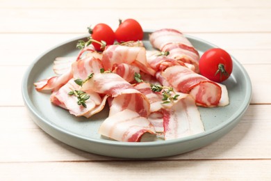 Photo of Slices of raw bacon, microgreens and tomatoes on wooden table