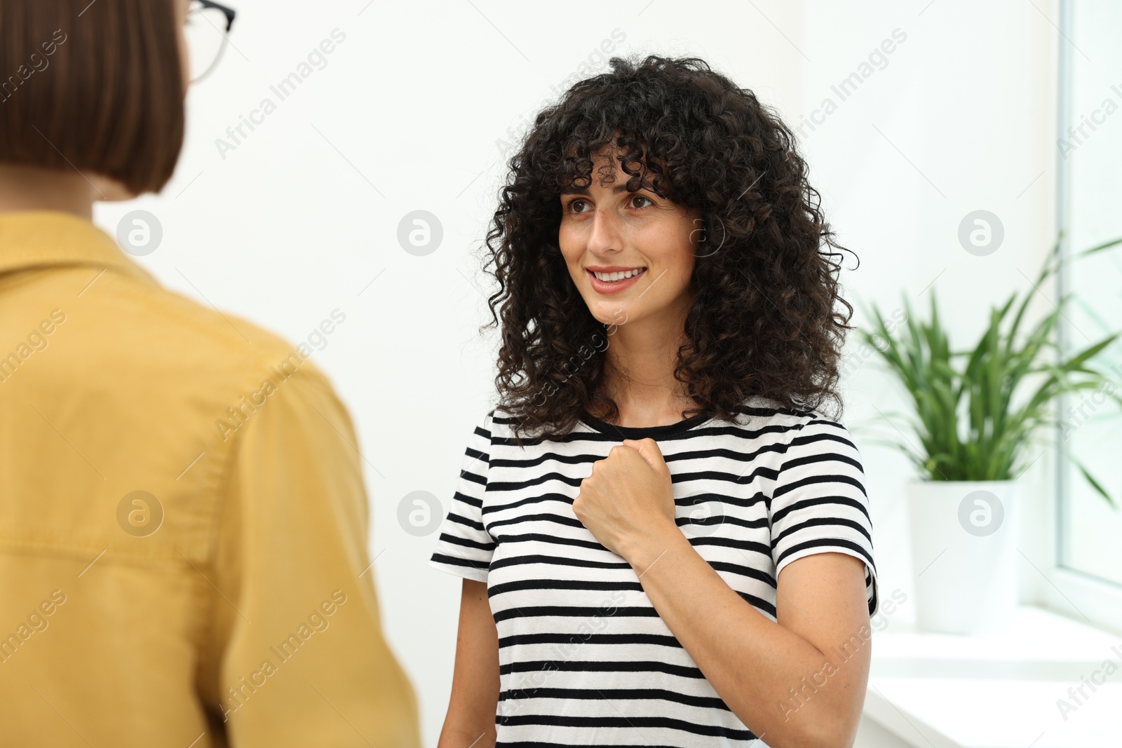 Photo of Young women using sign language for communication indoors