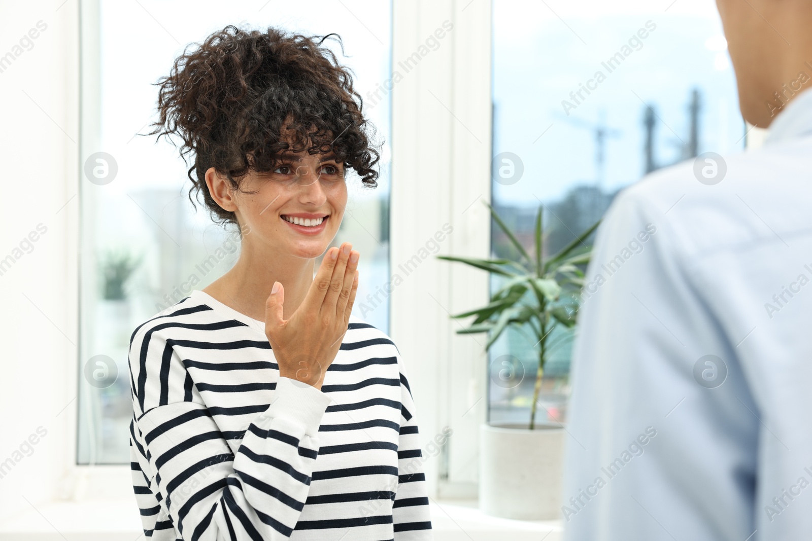 Photo of Man and woman using sign language for communication indoors