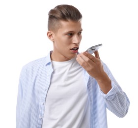 Young man recording voice message via smartphone on white background