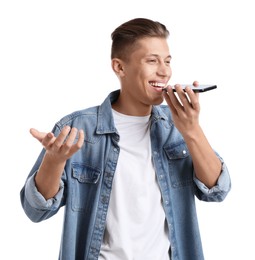 Young man recording voice message via smartphone on white background