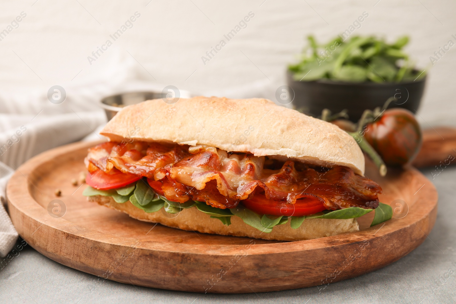 Photo of Tasty sandwich with bacon on grey table, closeup