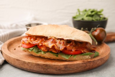 Photo of Tasty sandwich with bacon on grey table, closeup