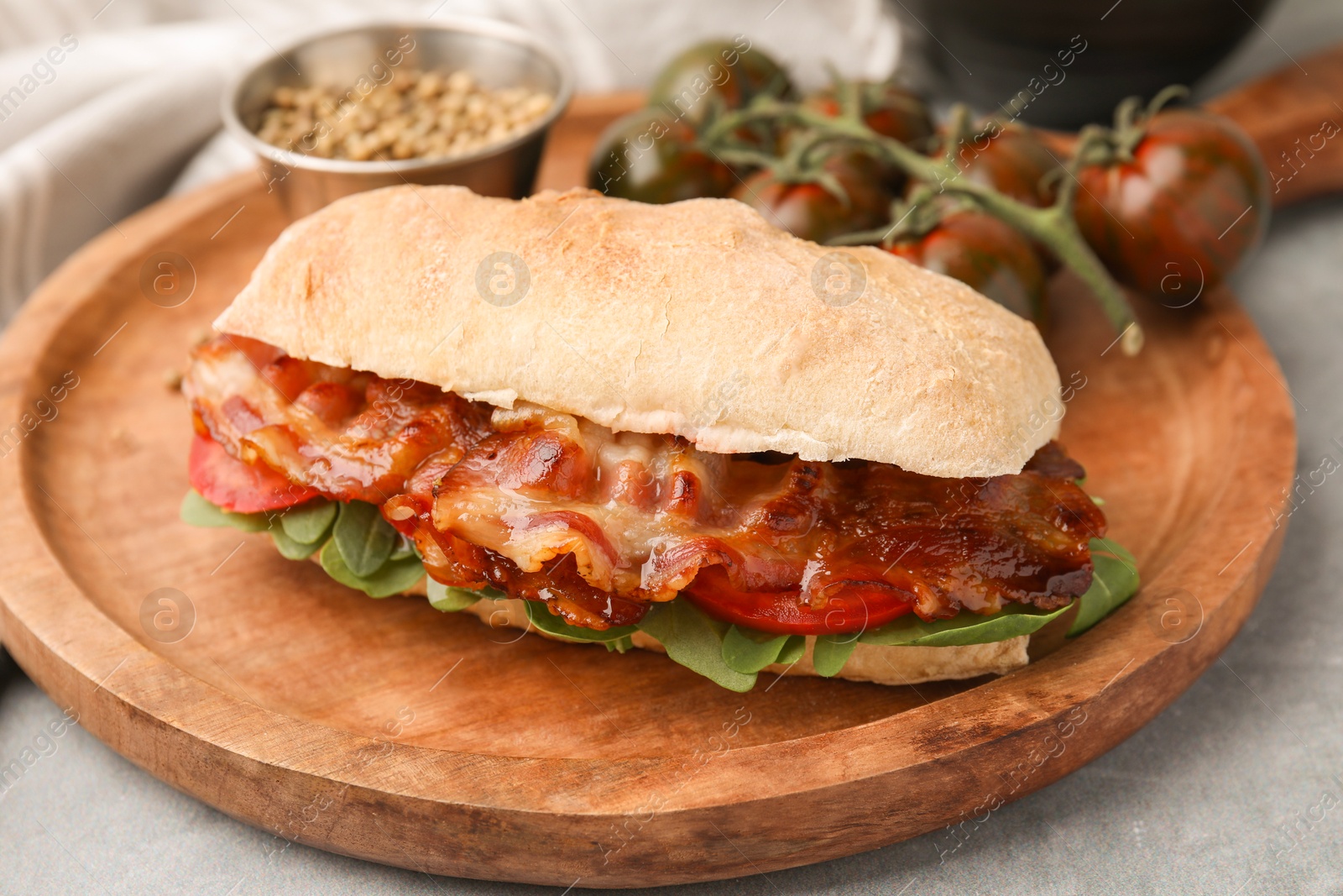 Photo of Tasty sandwich with bacon on grey table, closeup