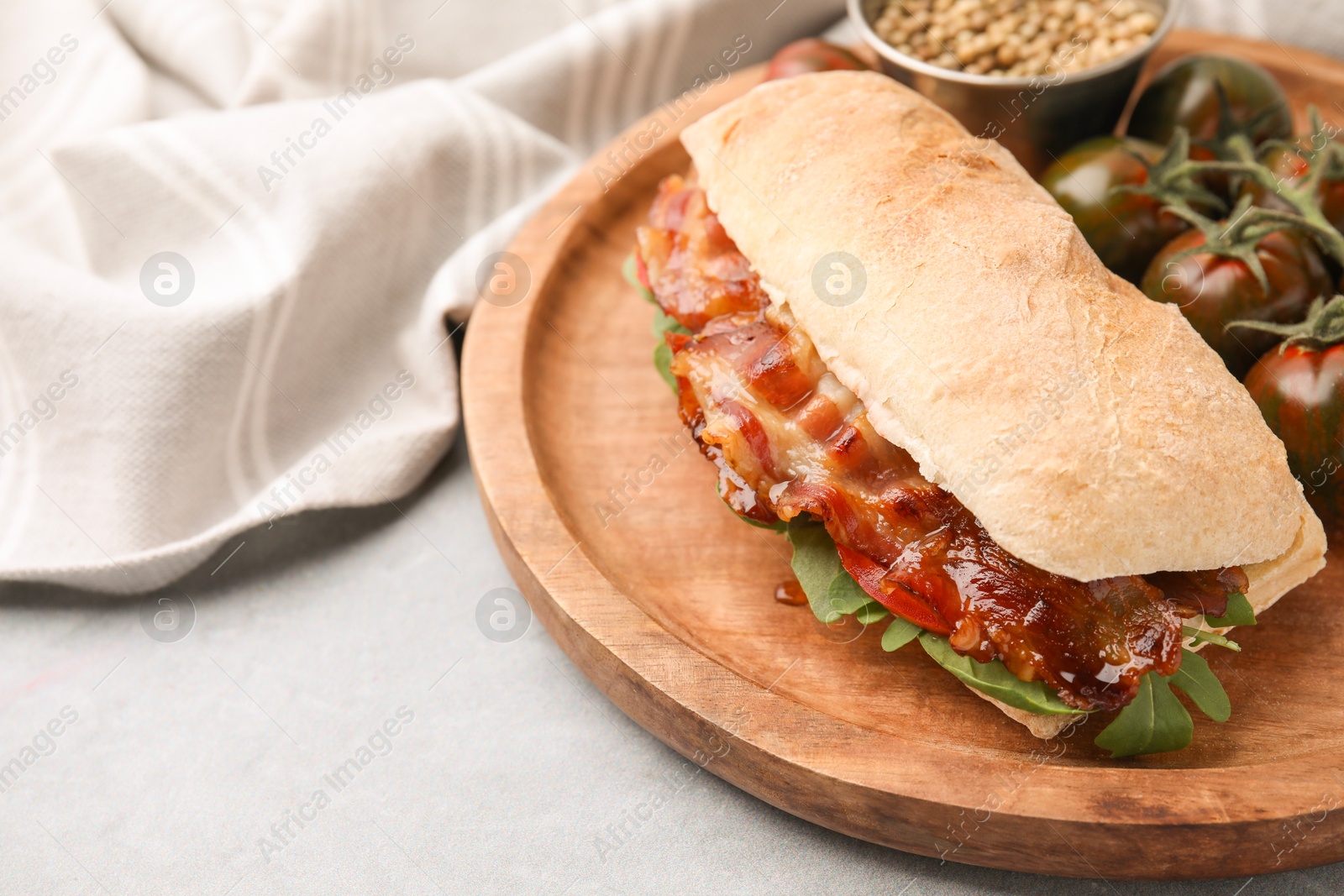 Photo of Tasty sandwich with bacon on grey table