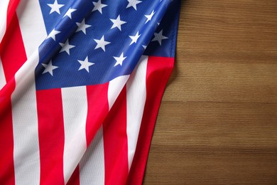 Photo of Flag of USA on wooden table, top view. Space for text