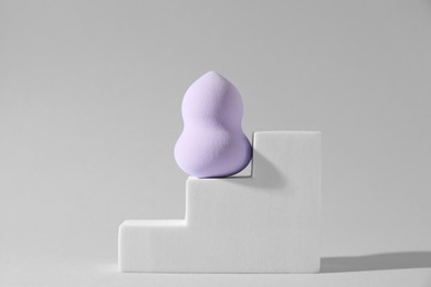 Stylish presentation of makeup sponge on light grey background