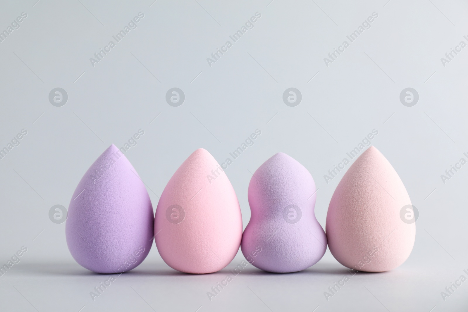 Photo of Many makeup sponges on light grey background