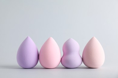 Photo of Many makeup sponges on light grey background