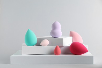 Stylish presentation of makeup sponges on light grey background