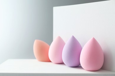 Stylish presentation of makeup sponges on light grey background