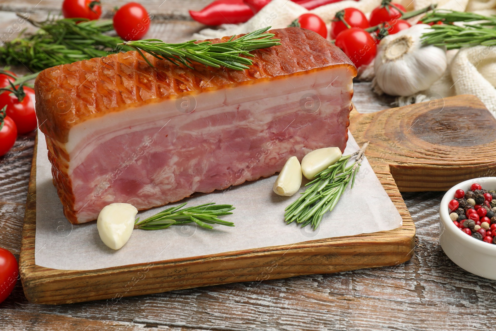 Photo of Piece of raw bacon with spices and cherry tomatoes on wooden table