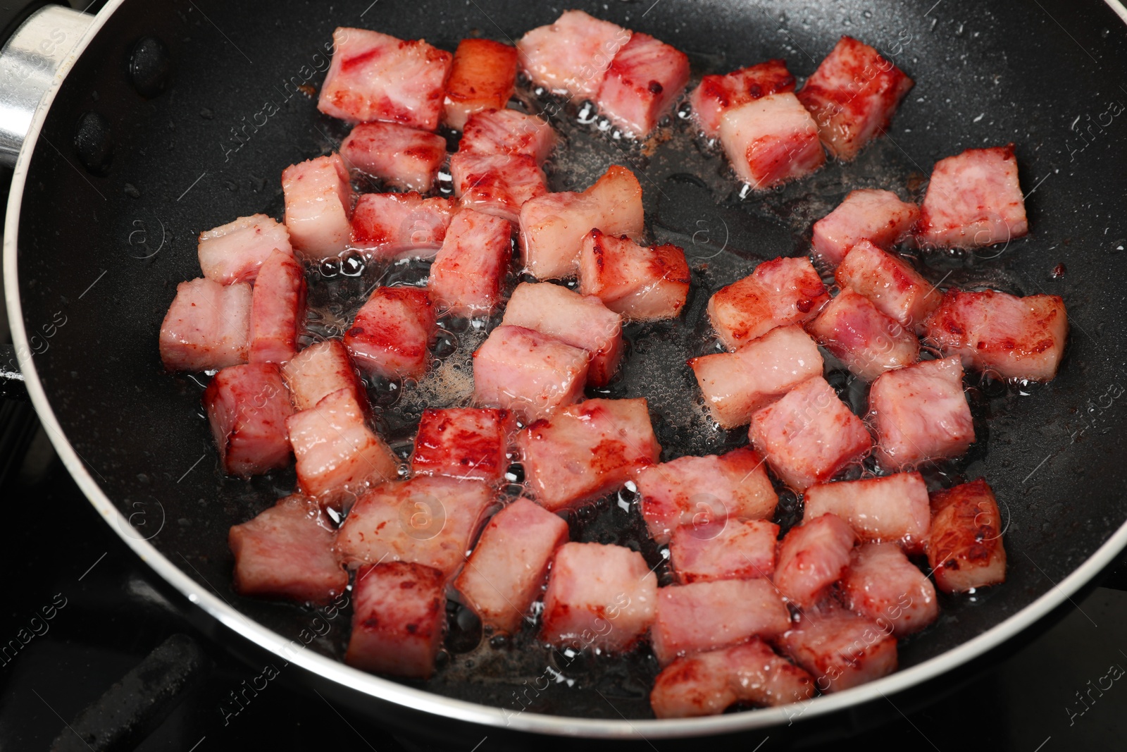 Photo of Pieces of bacon frying in pan, closeup