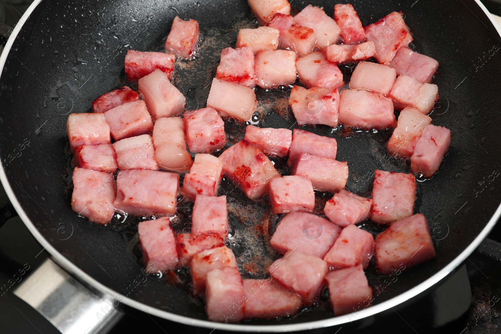 Photo of Pieces of bacon frying in pan, closeup