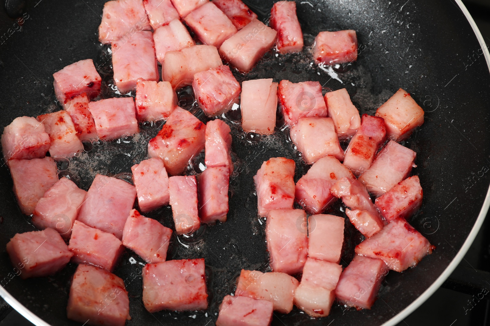 Photo of Pieces of bacon frying in pan, closeup