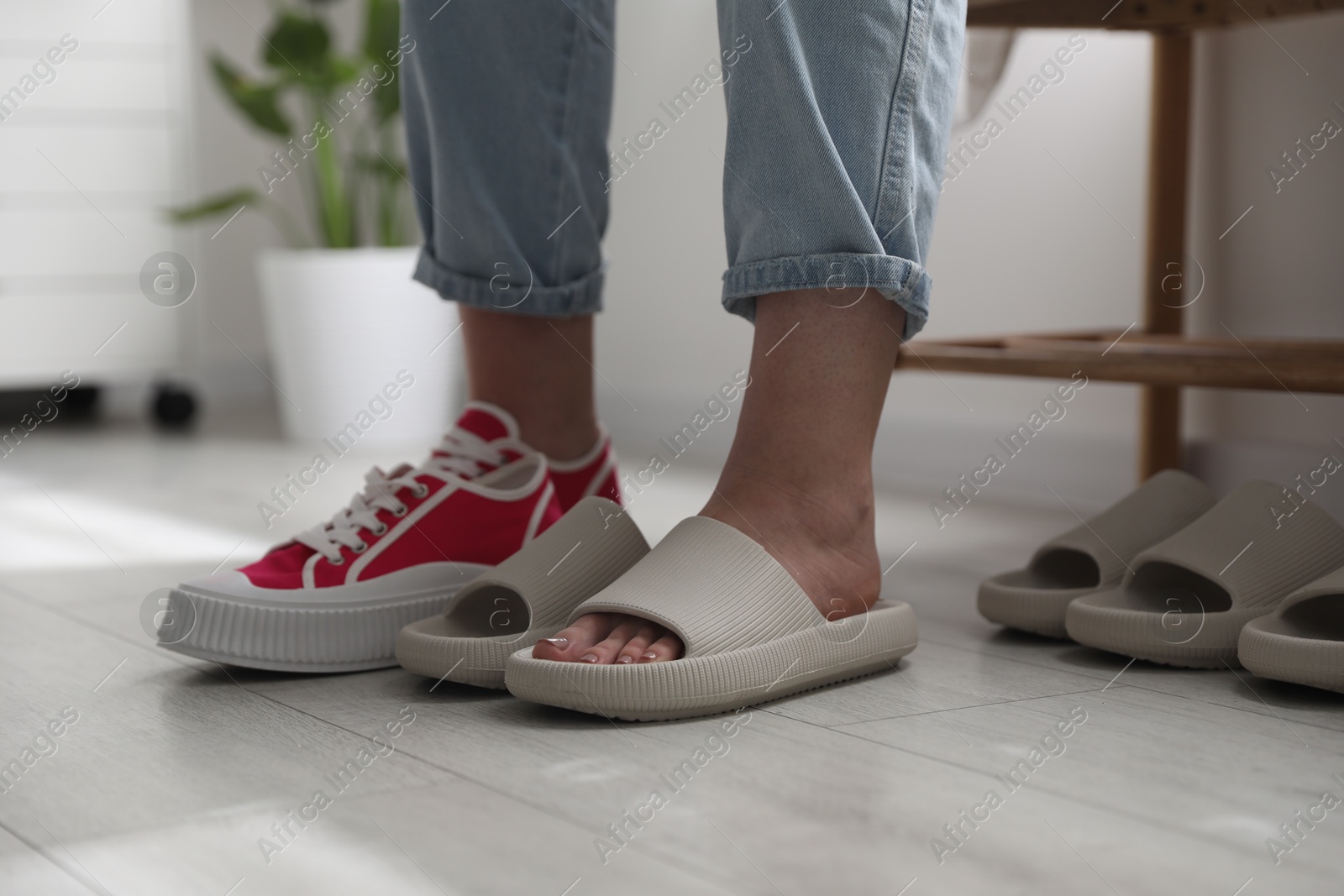 Photo of Woman changing into slippers at home, closeup