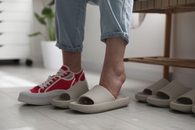 Woman changing into slippers at home, closeup