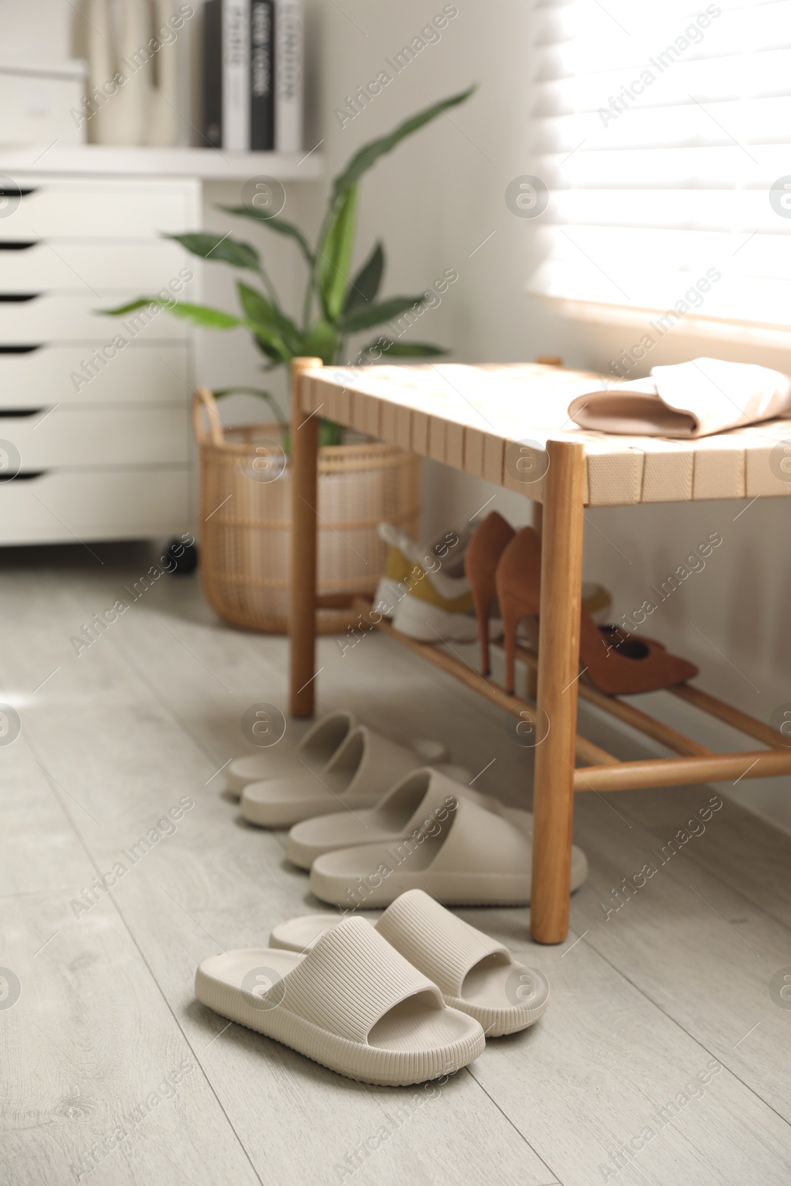 Photo of Many pairs of slippers and other shoes in entryway at home