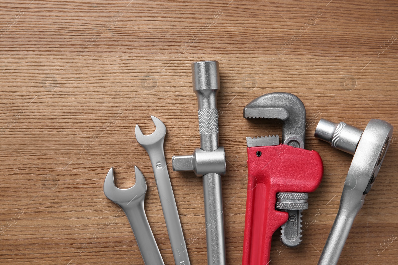 Photo of Different auto mechanic's tools on wooden table, flat lay