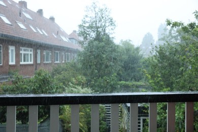 View on buildings and trees from balcony on rainy day