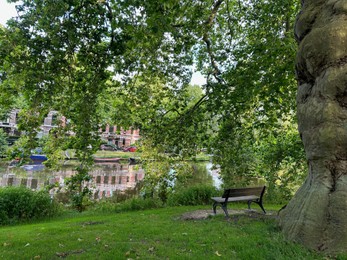 Beautiful view of wooden bench near canal in park