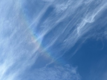 Beautiful blue sky with rainbow, low angle view