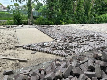 Photo of Process of laying paving stone blocks outdoors