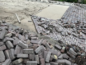 Photo of Process of laying paving stone blocks outdoors