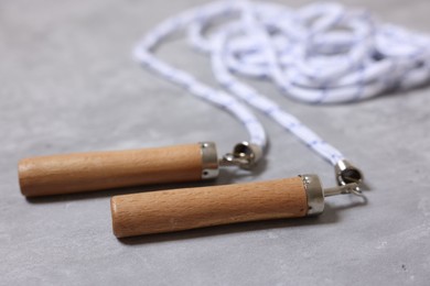 Photo of Skipping rope on grey table, closeup. Sports equipment