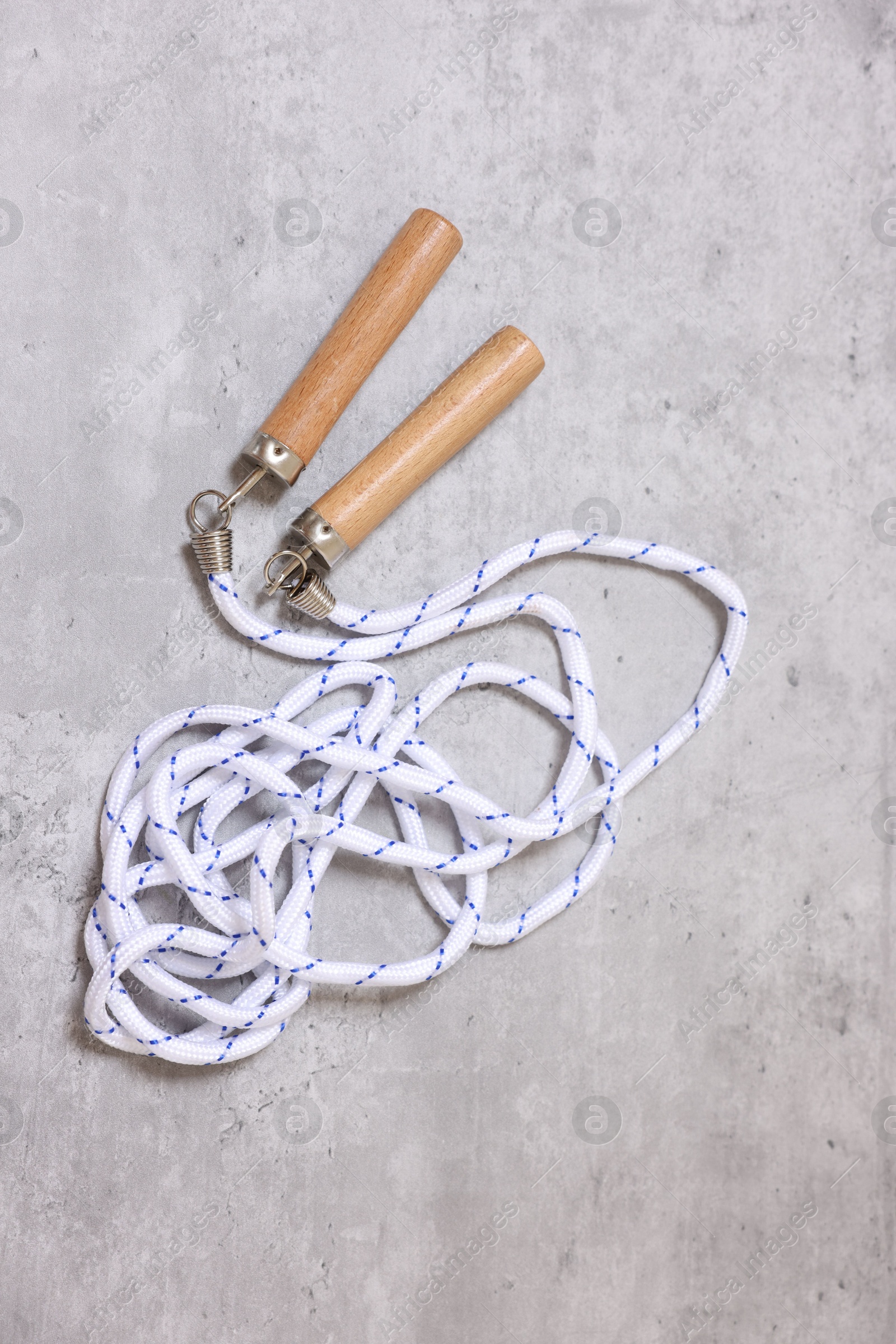 Photo of Skipping rope on grey table, top view. Sports equipment