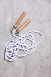 Skipping rope on grey table, top view. Sports equipment