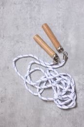 Photo of Skipping rope on grey table, top view. Sports equipment