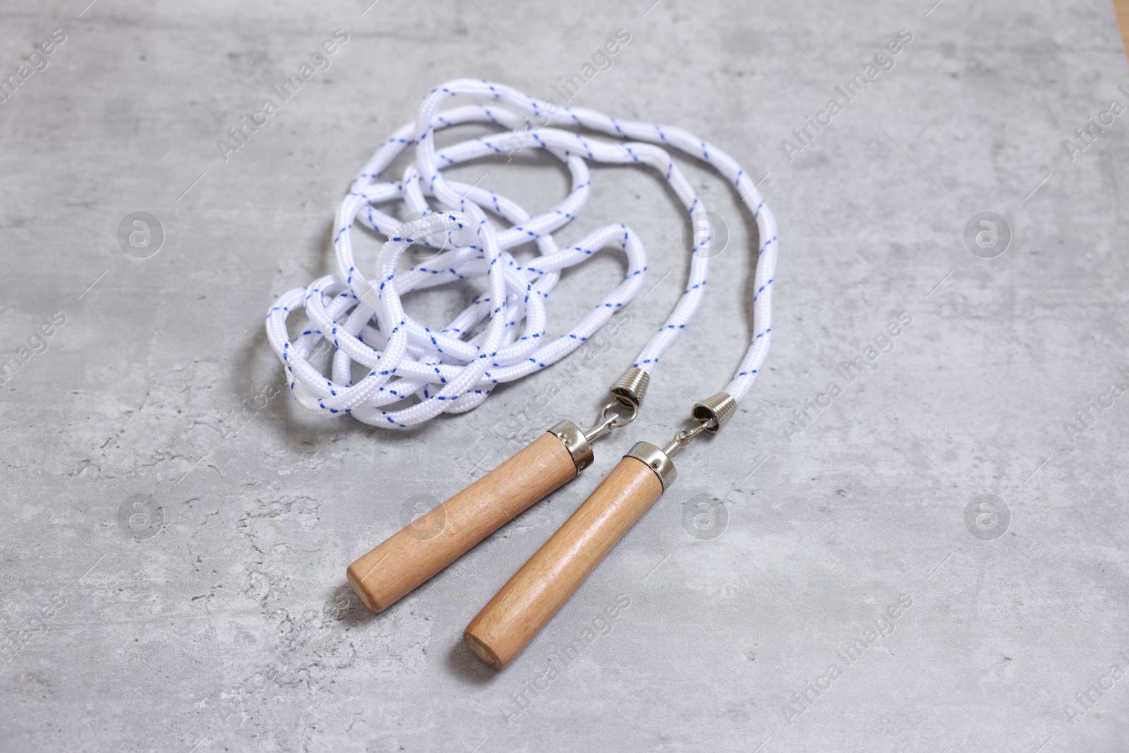 Photo of Skipping rope on grey table. Sports equipment